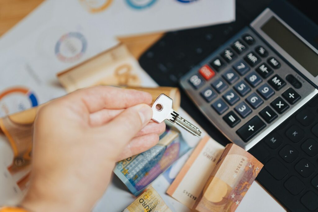 A person is putting money in front of a calculator